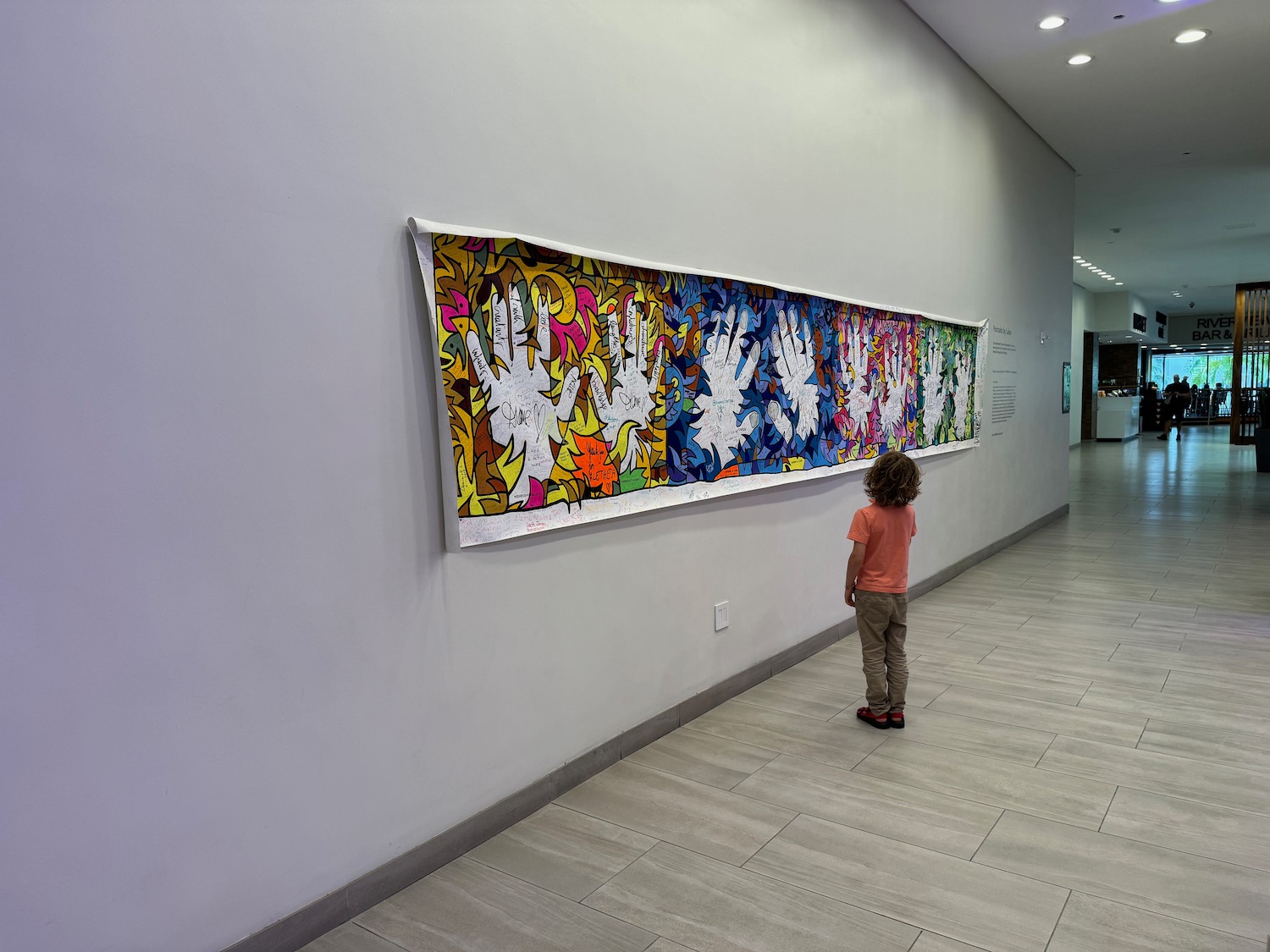 a child looking at a piece of art on a wall