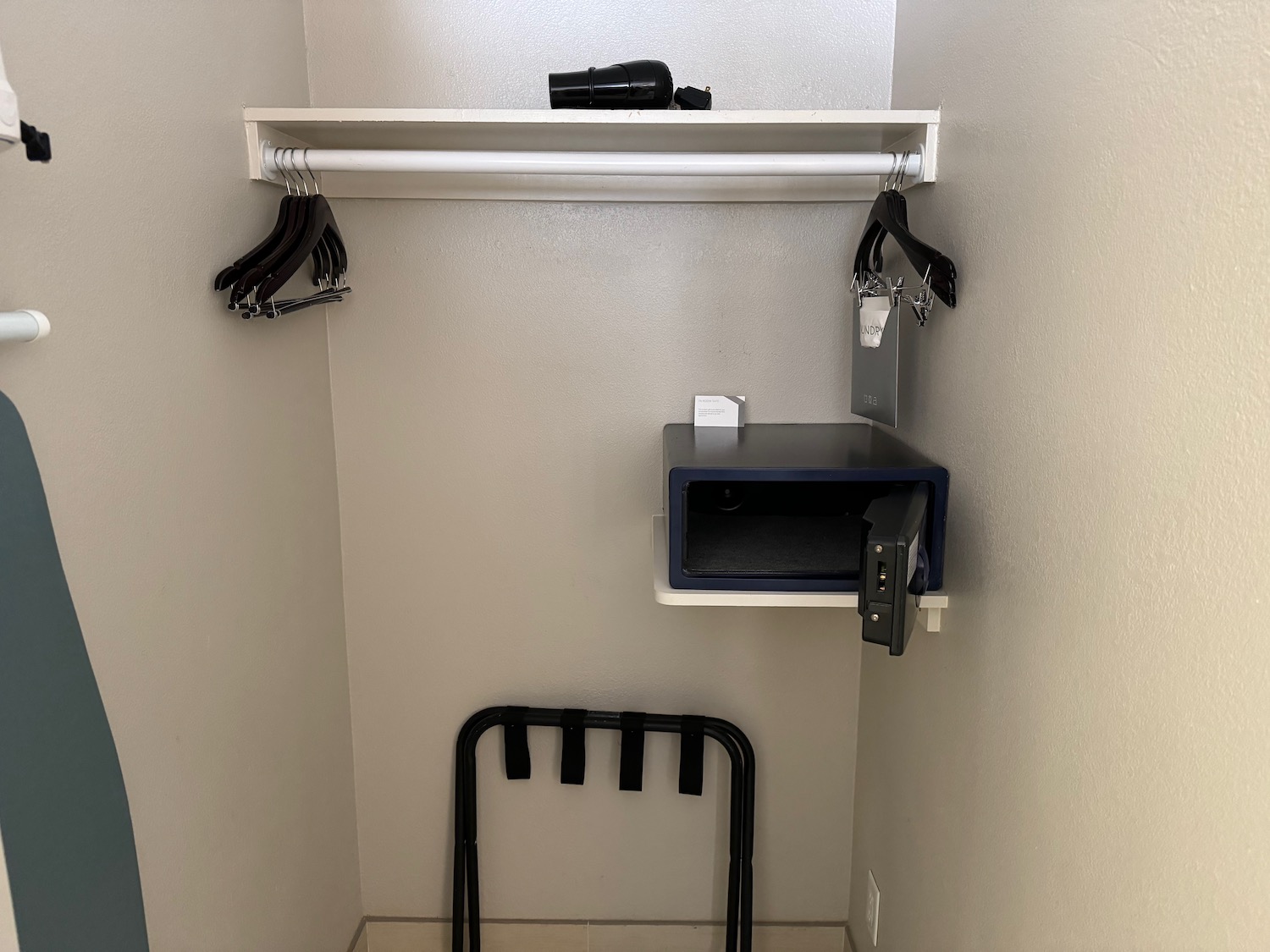 a small closet with a shelf and a shelf with a metal box and a belt