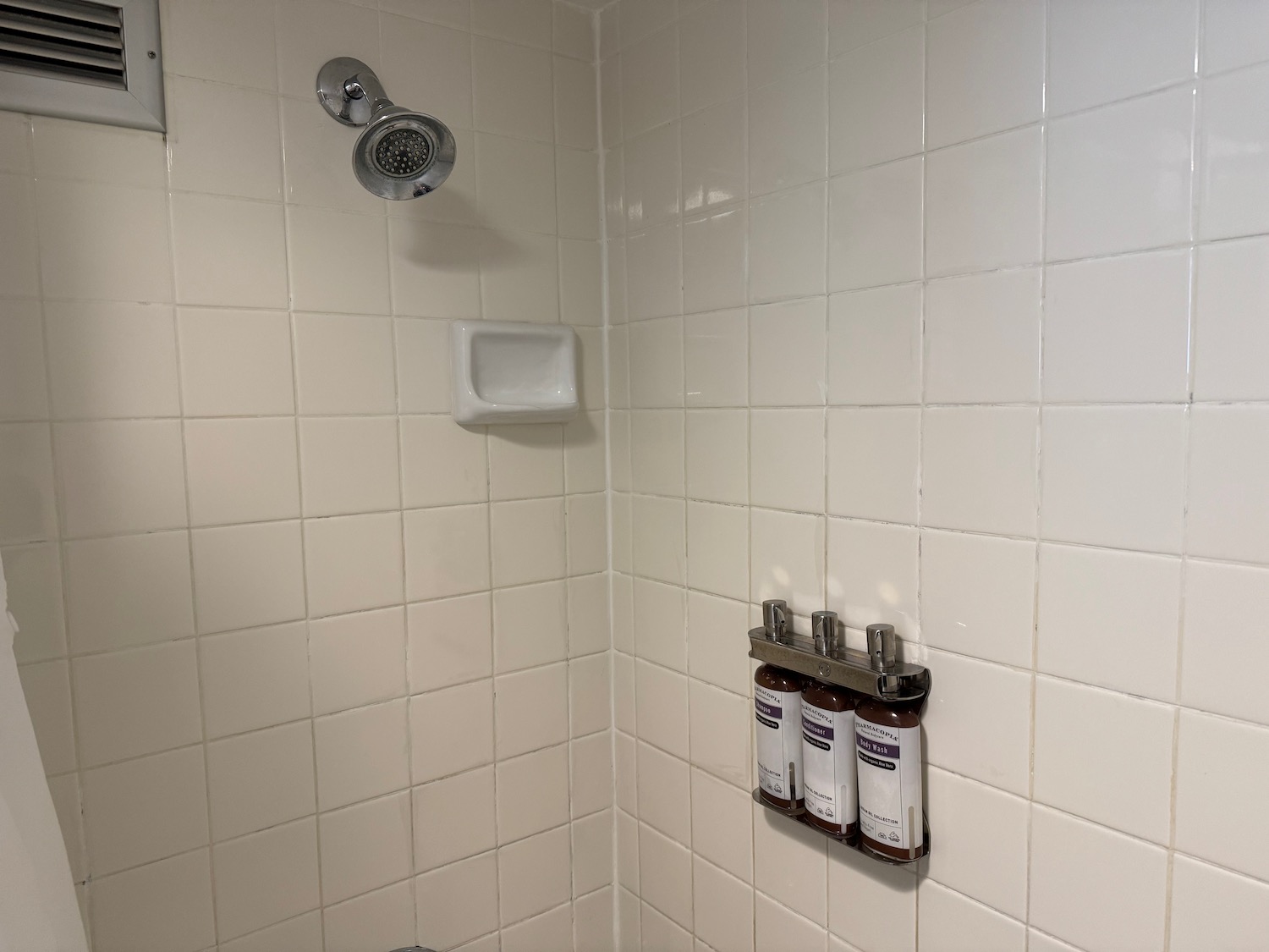 a shower with white tile walls