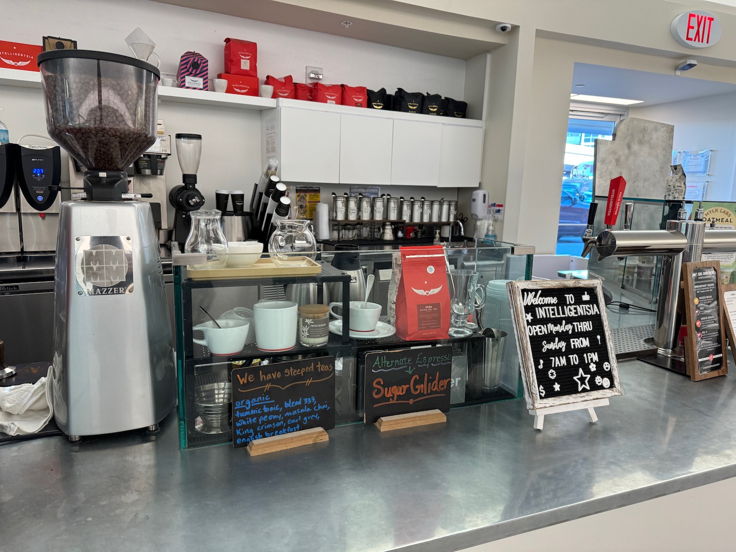 a counter with a coffee machine and a sign