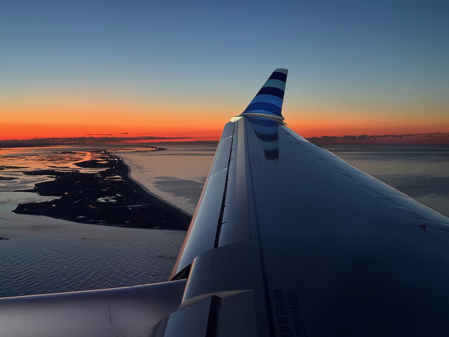 an airplane wing with a sunset in the background