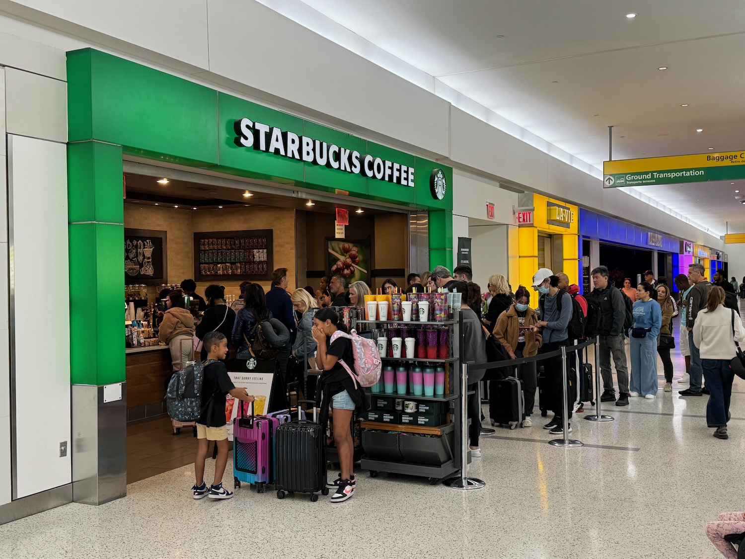 a group of people in a line at a starbucks coffee shop