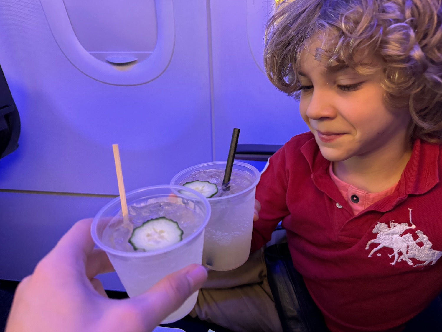 a child holding two cups of drinks