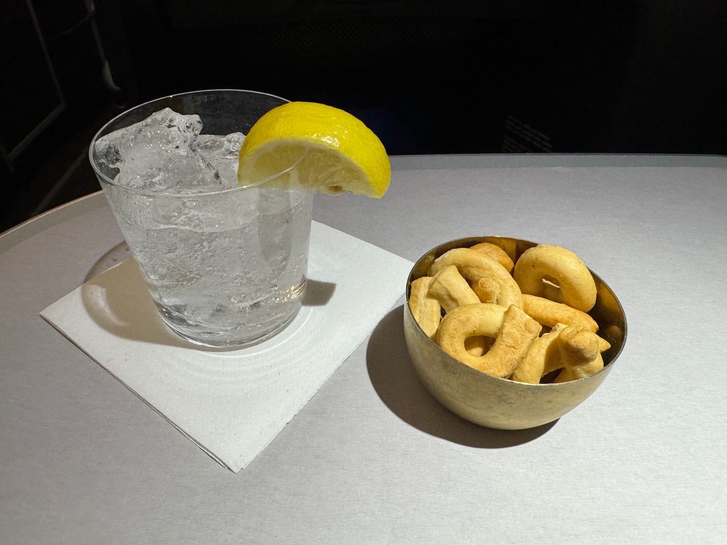 a bowl of food and a glass of water with a lemon wedge