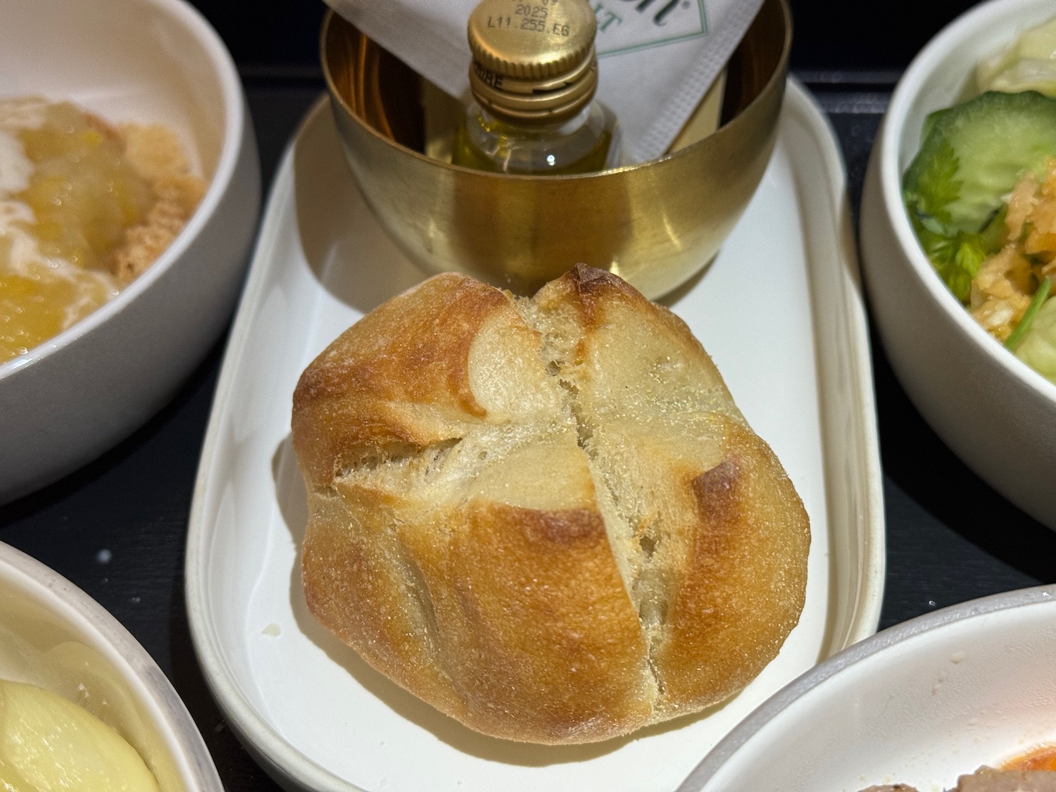 a small bowl of oil and a piece of bread on a tray