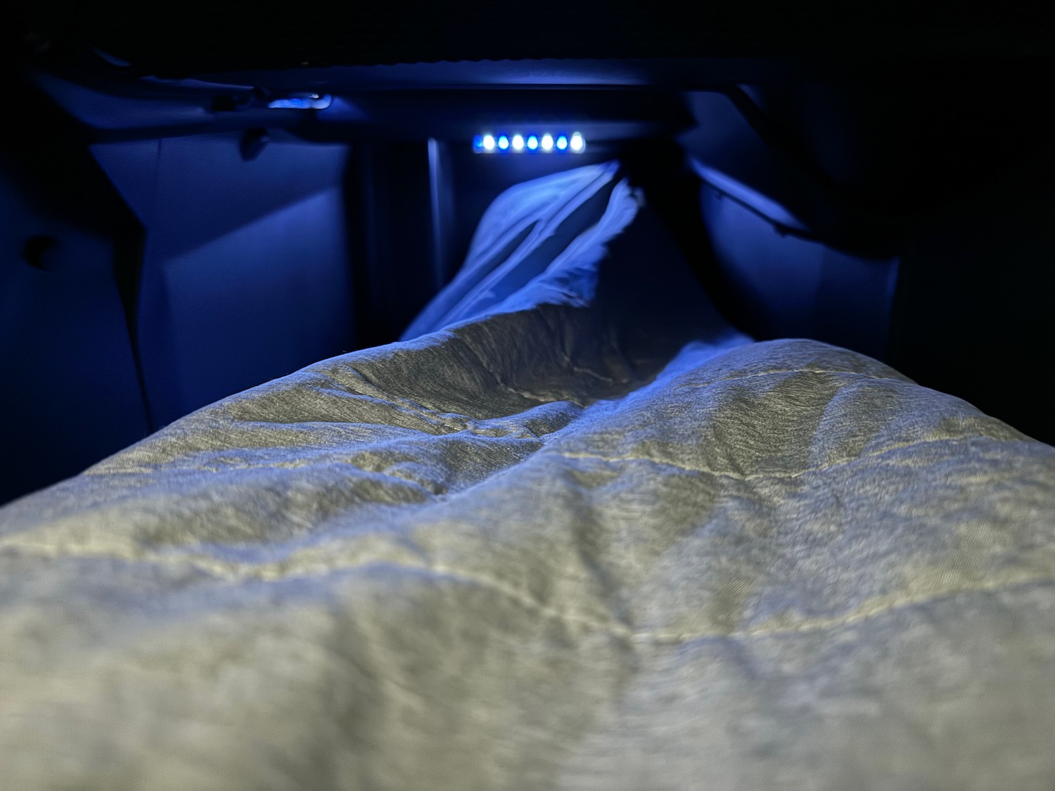 a bed with a blanket and a blue light