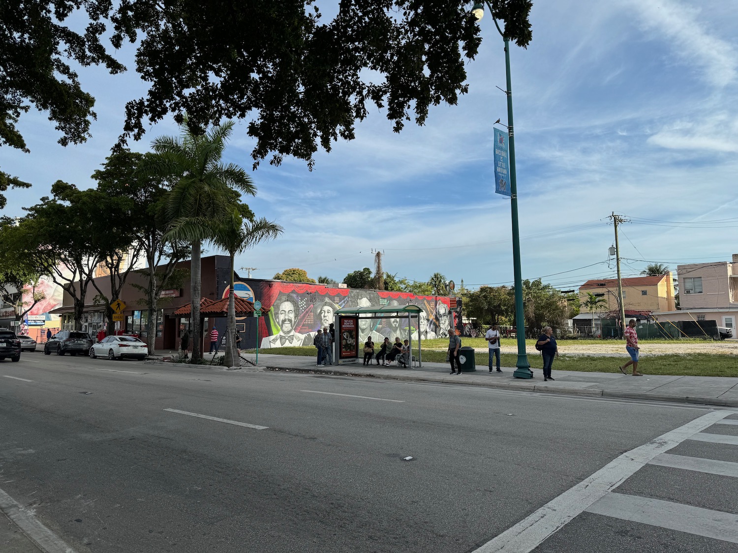 a street with a bus stop and people on it