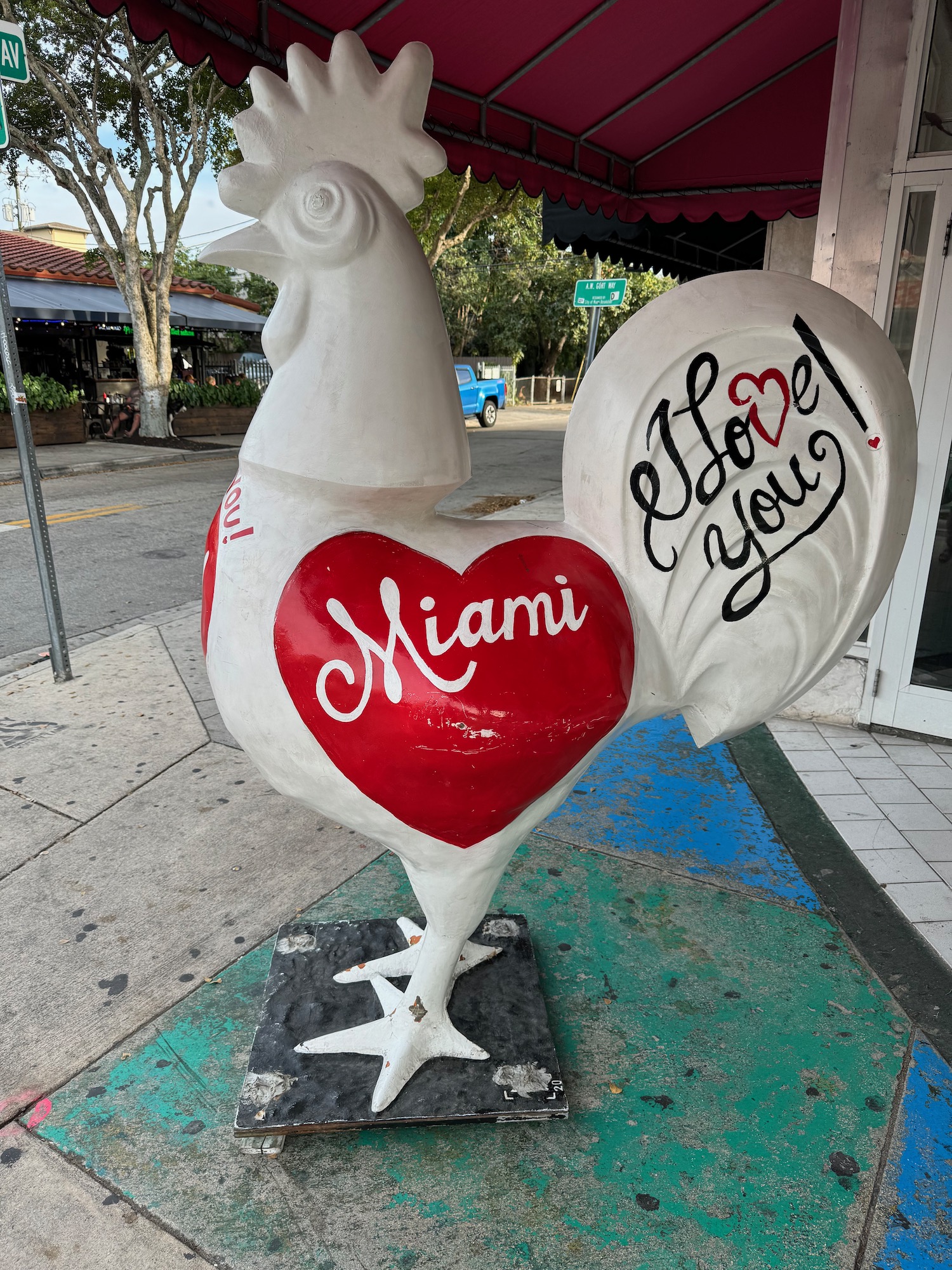 a statue of a rooster with a red heart on it