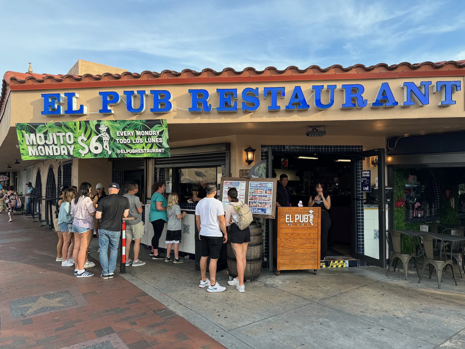 a group of people standing outside of a restaurant