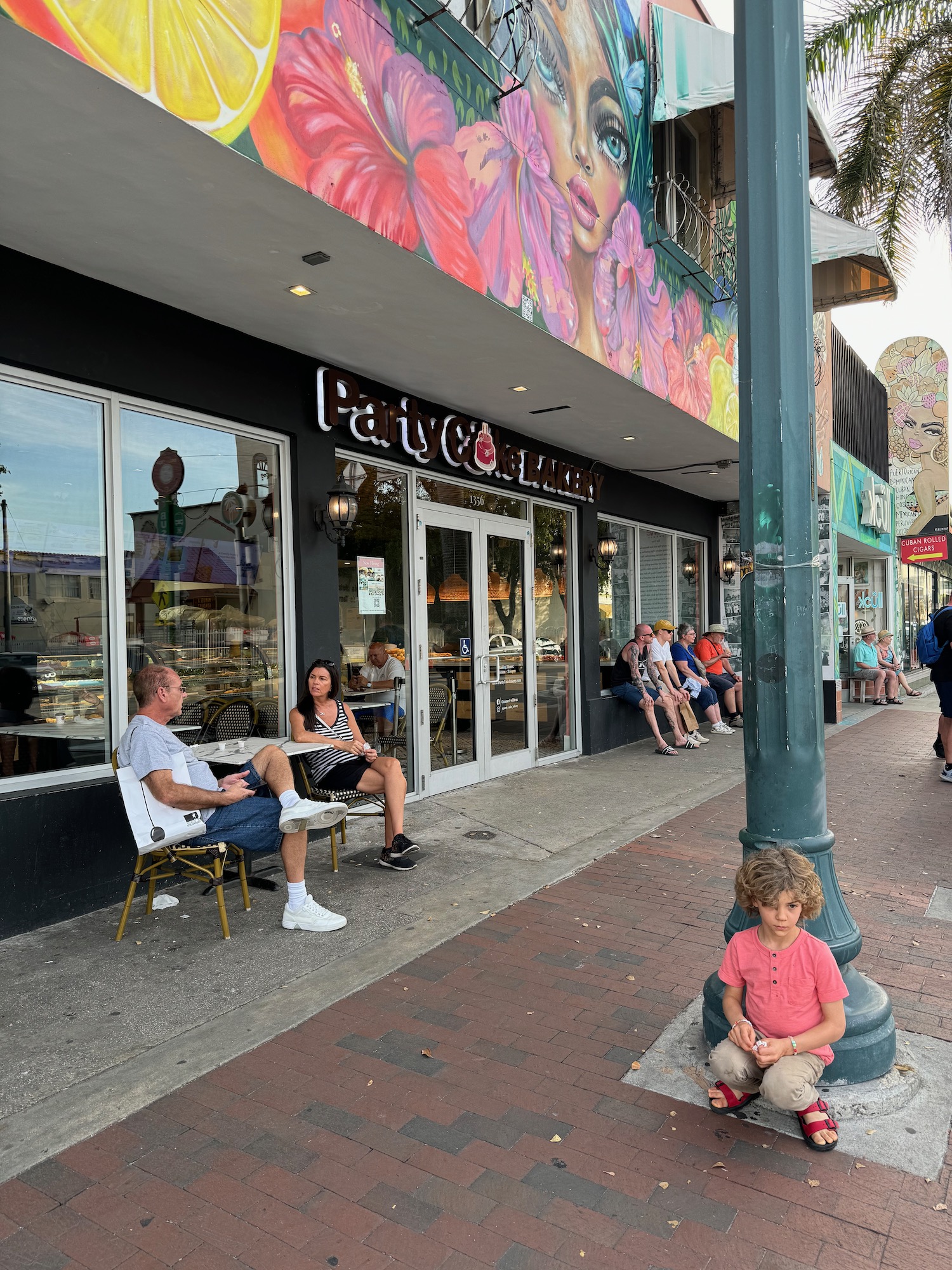 a group of people sitting on a sidewalk