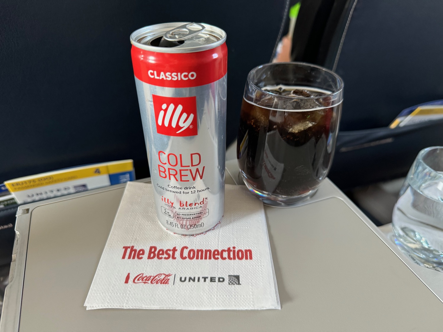 a can of soda next to a glass of soda