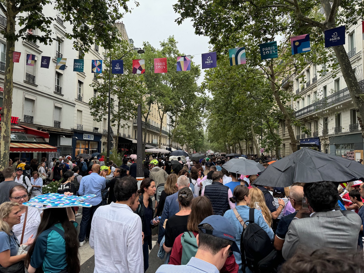 a crowd of people walking down a street with umbrellas