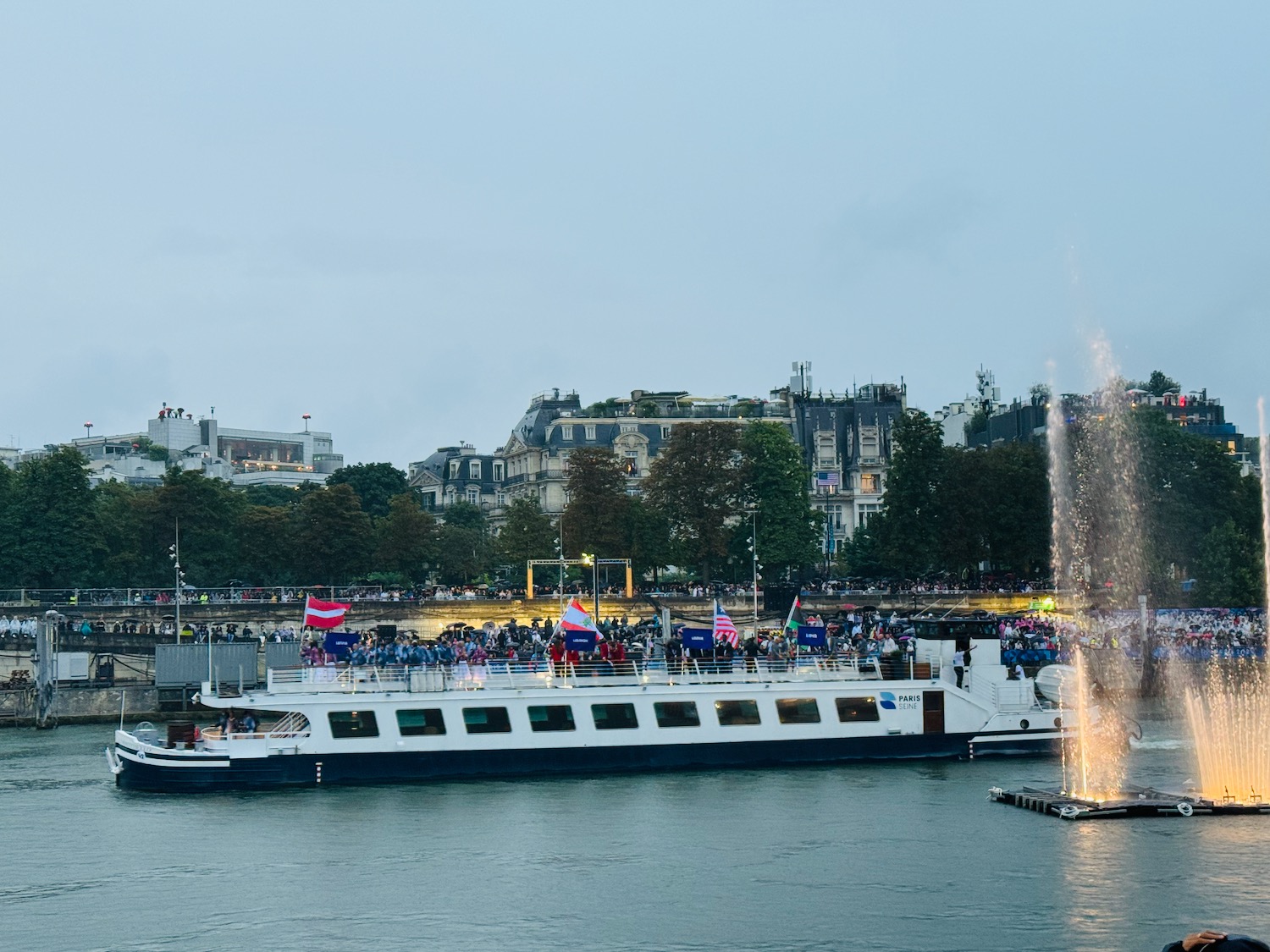 a boat on the water with a fountain in front of it