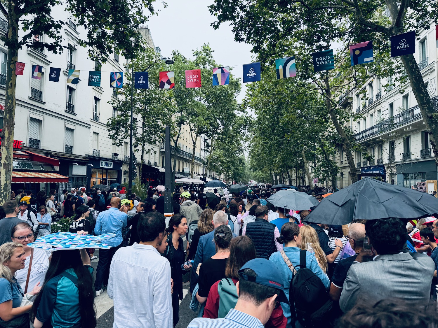 a crowd of people walking down a street with umbrellas