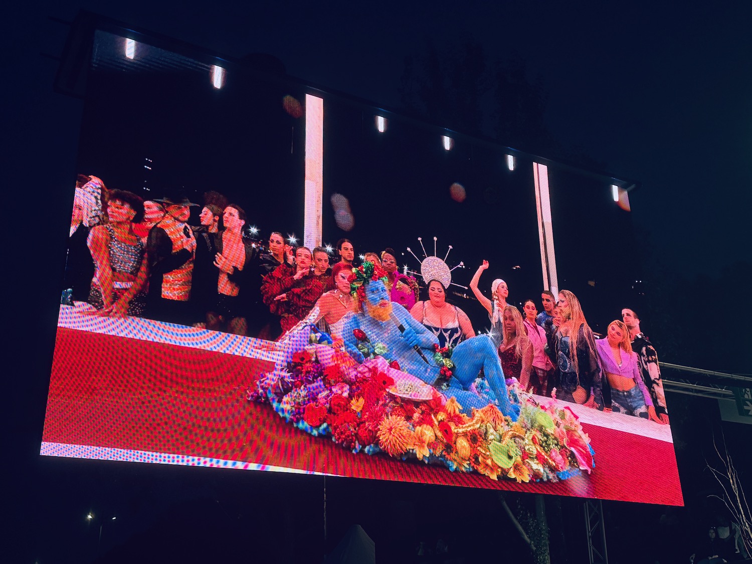 a large screen with a group of people on it