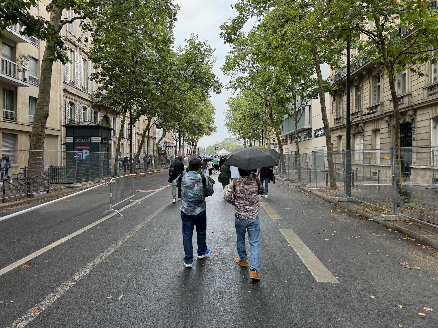 people walking down a street with people holding umbrellas