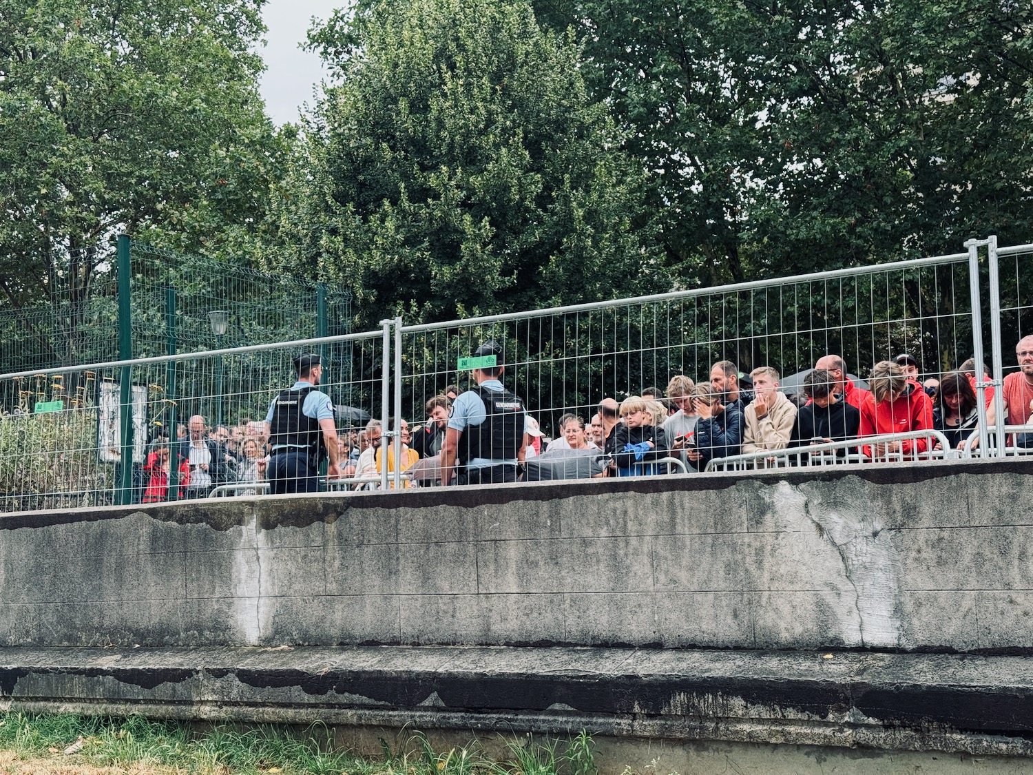 a group of people standing behind a fence