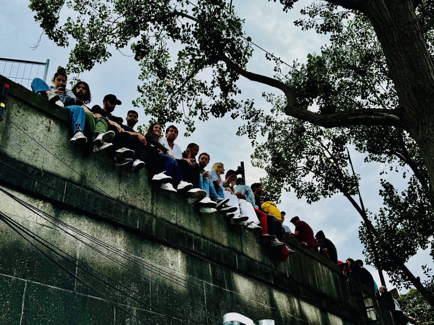 a group of people sitting on a wall