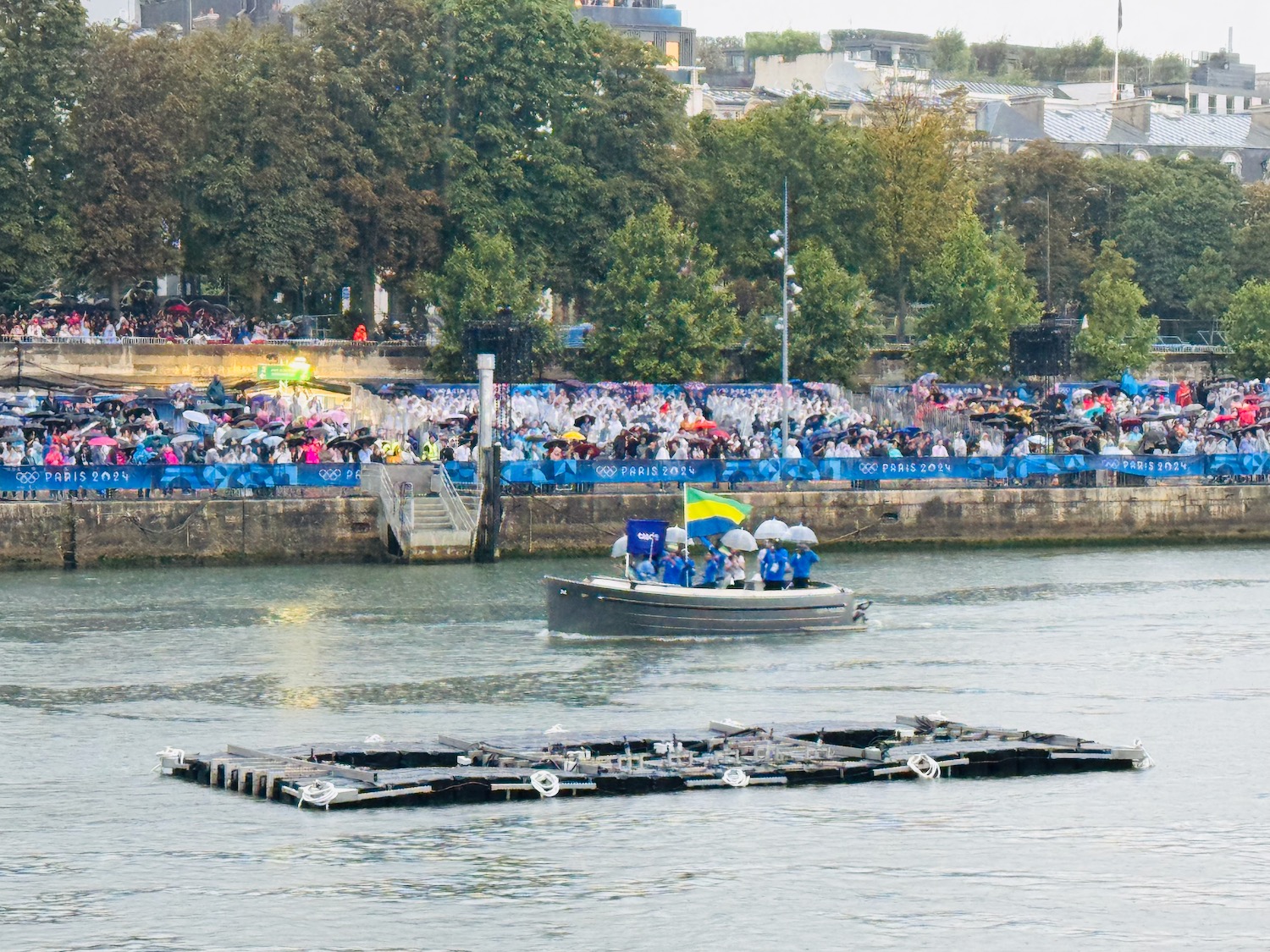 a boat with people on it in the water with a crowd of people watching