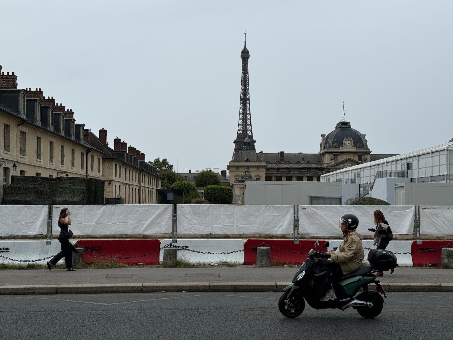 a man on a motorcycle on a street with a tower in the background