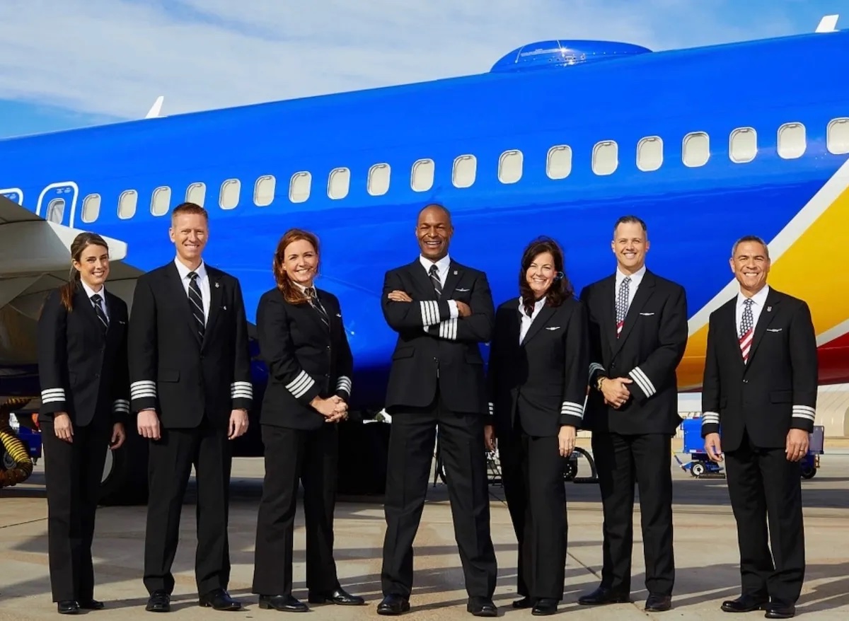 a group of people in uniform standing in front of a plane
