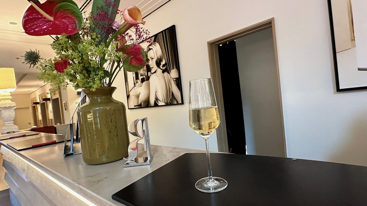 a glass of wine and flowers on a counter