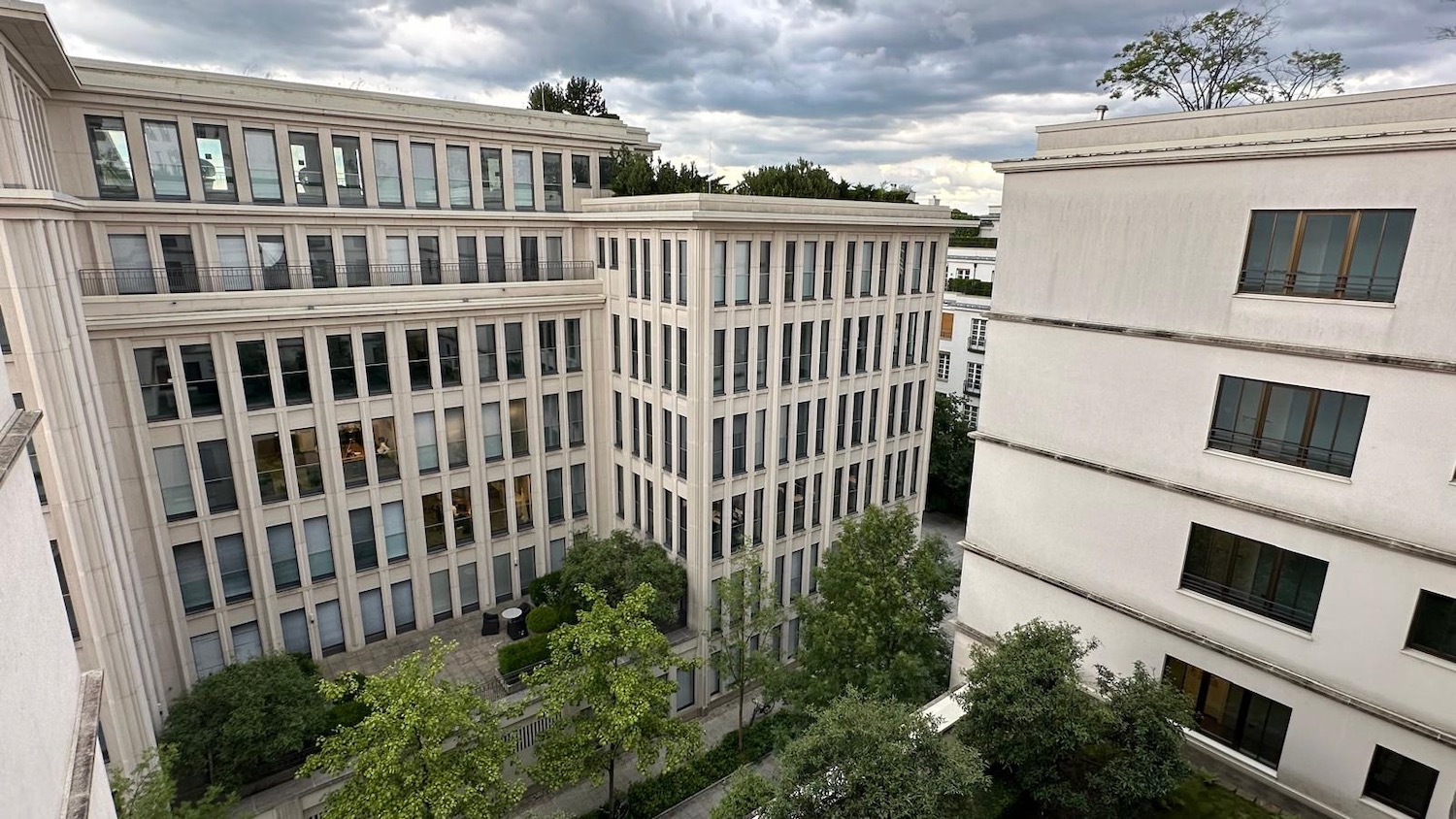 a building with trees and a sidewalk