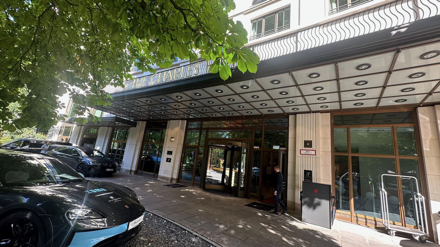 a building with glass doors and a car parked on the side