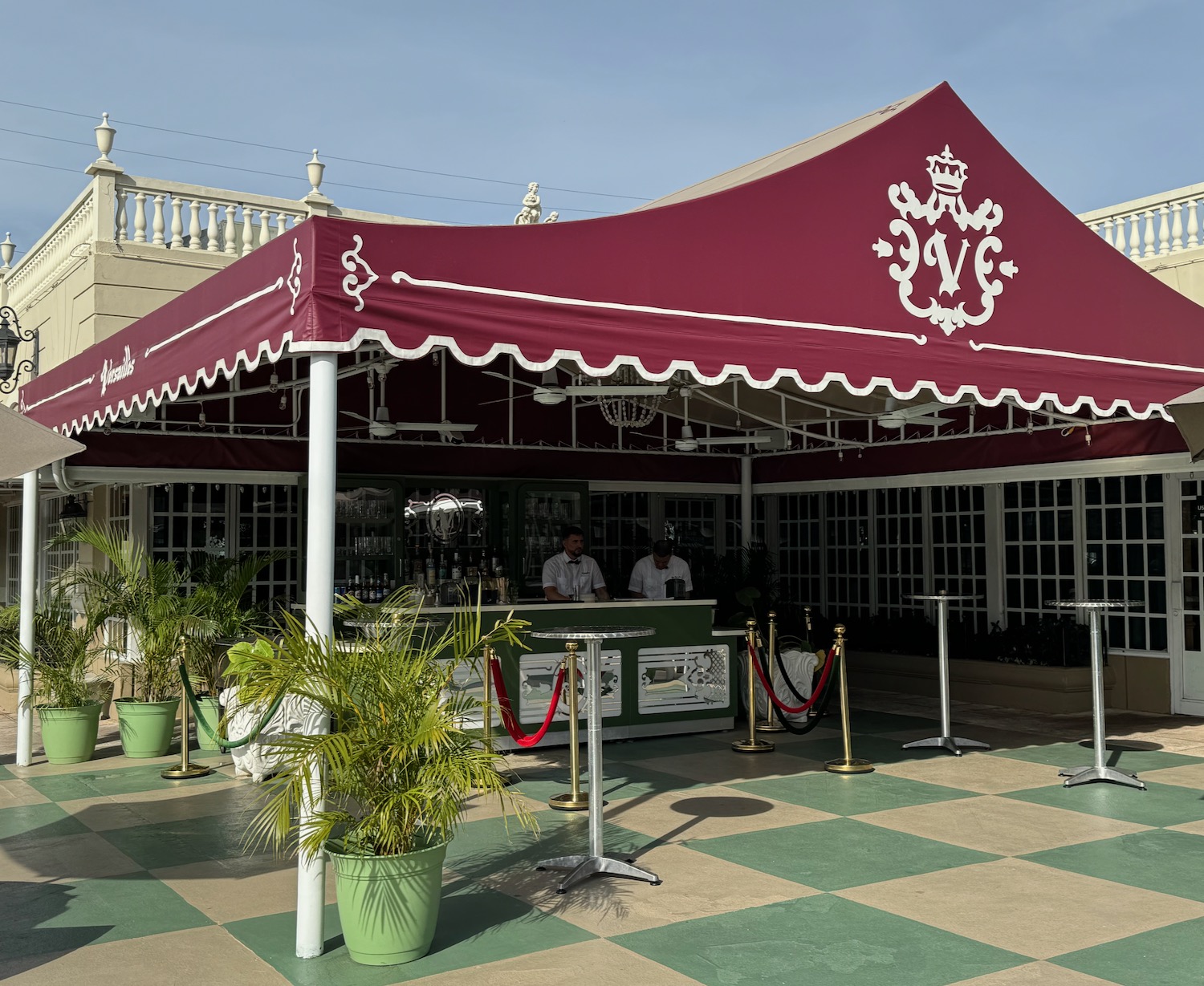 a red tent with white trim and a couple of people standing in front of a building