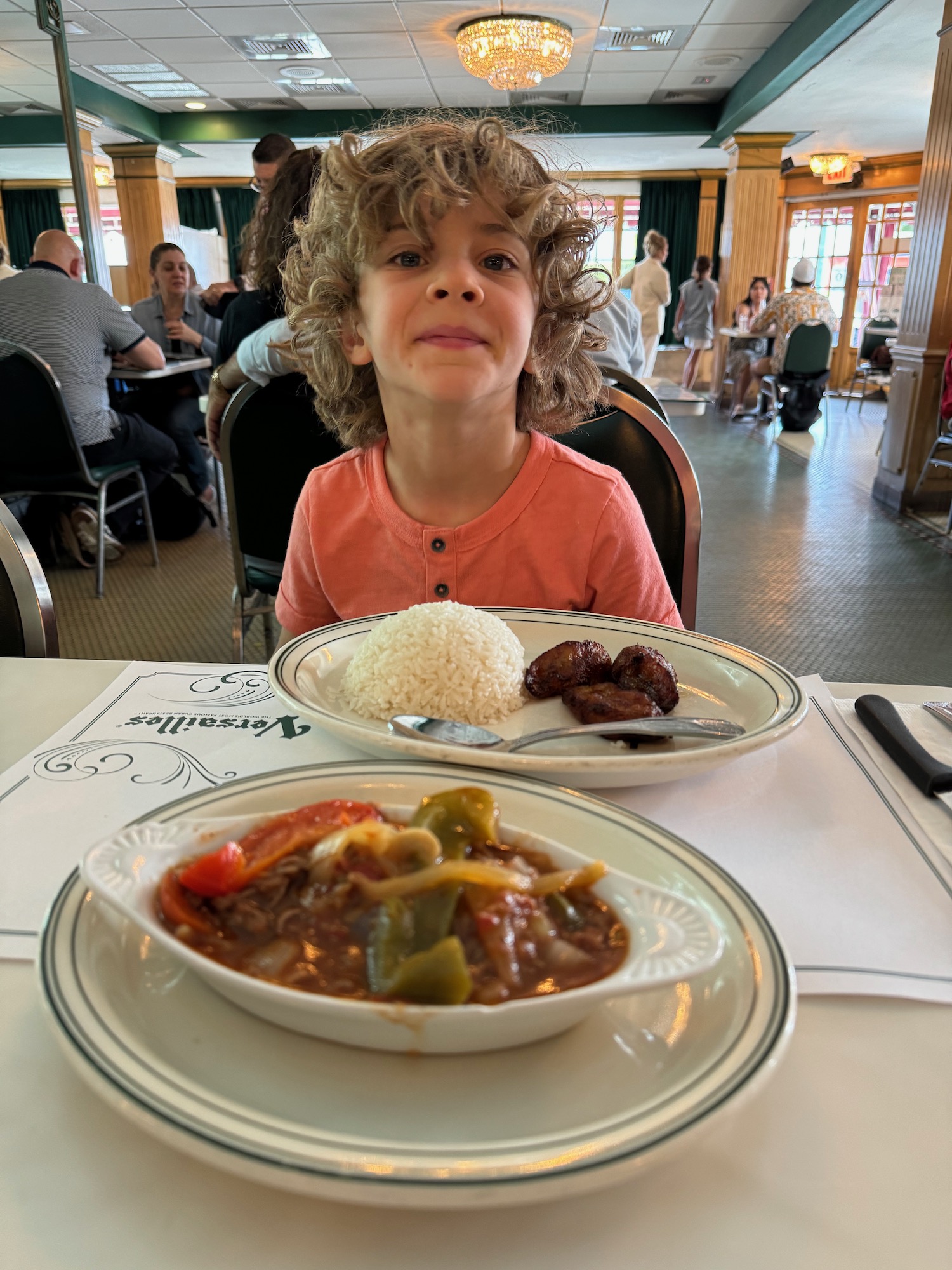 a boy sitting at a table with food