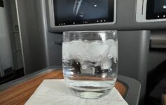 a glass of water with ice and a television on the wall