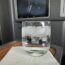 a glass of water with ice and a television on the wall