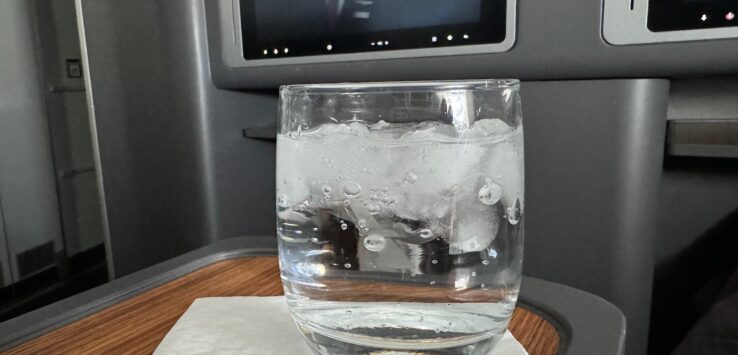 a glass of water with ice and a television on the wall