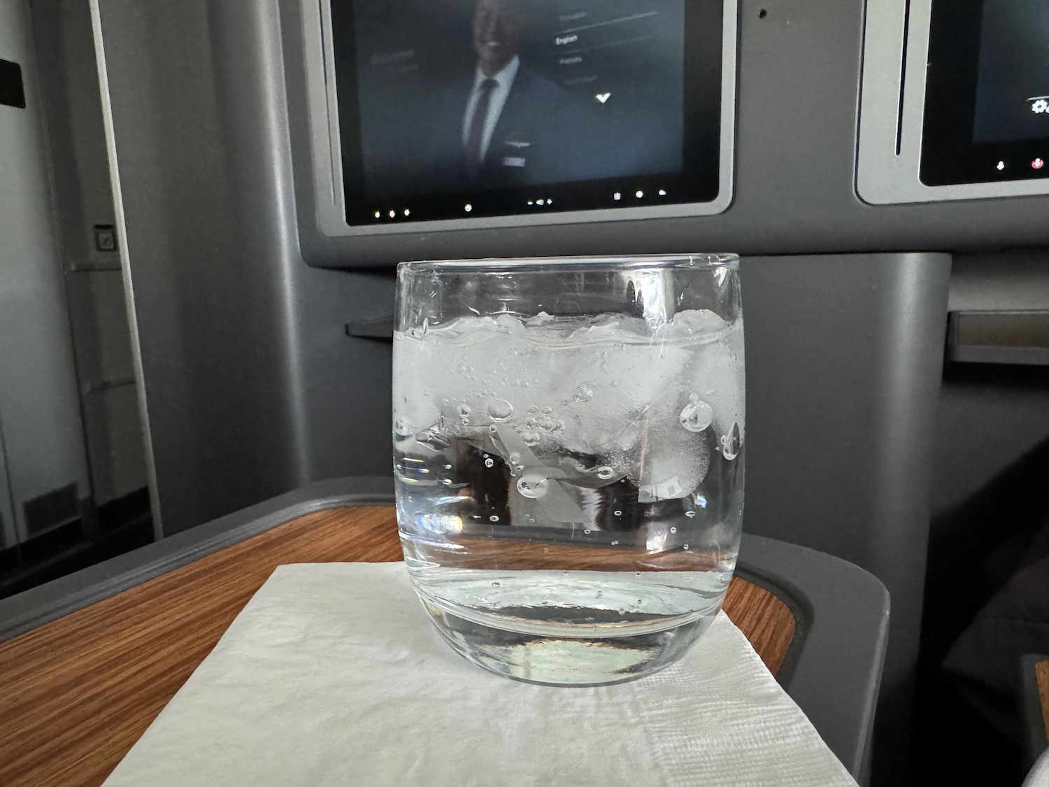 a glass of water with ice and a television on the wall