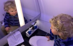 a child looking at a mirror in a bathroom