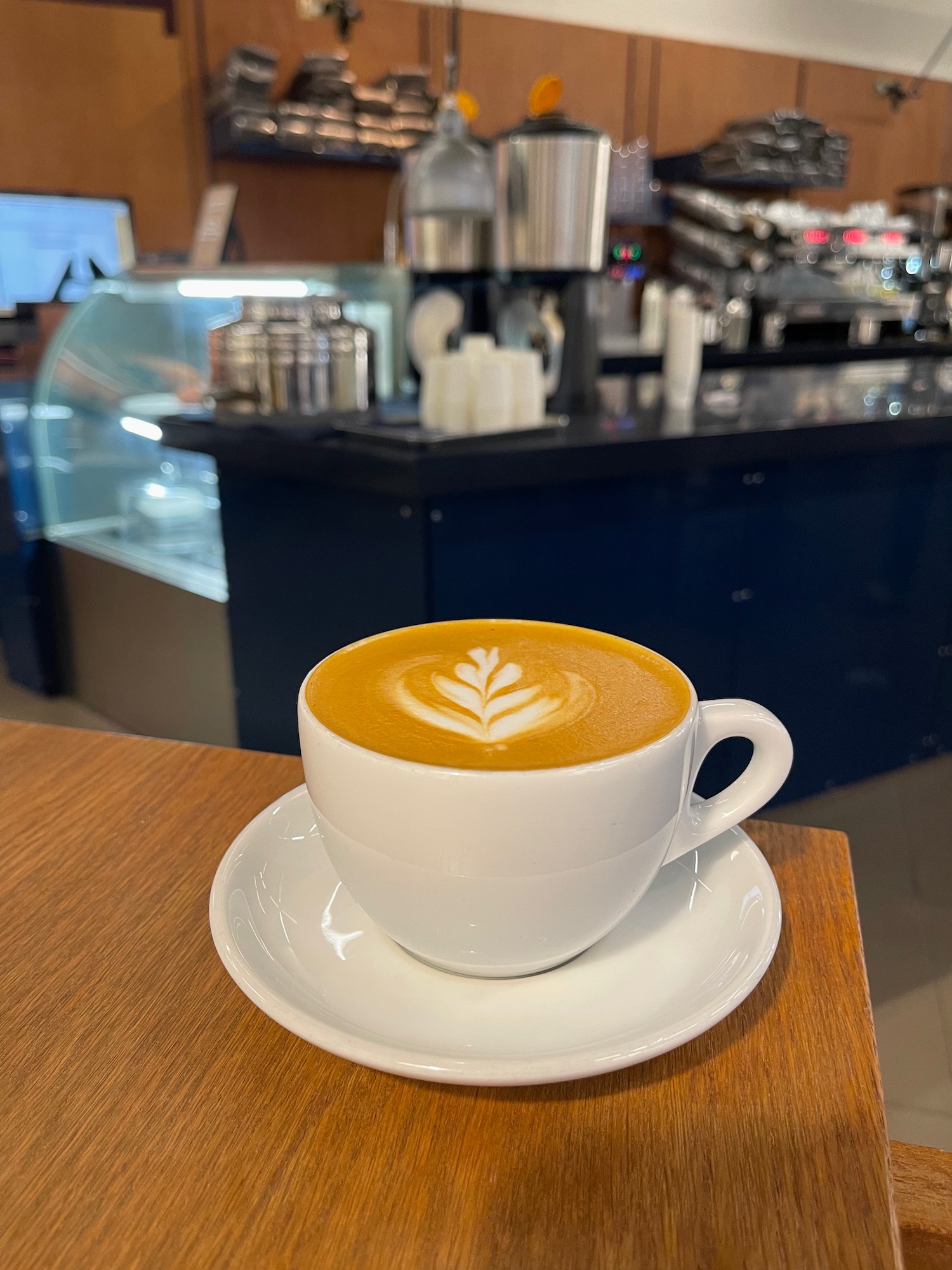 a cup of coffee with a leaf design in the foam