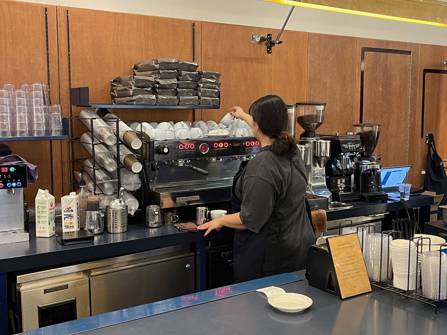 a woman making coffee at a coffee machine