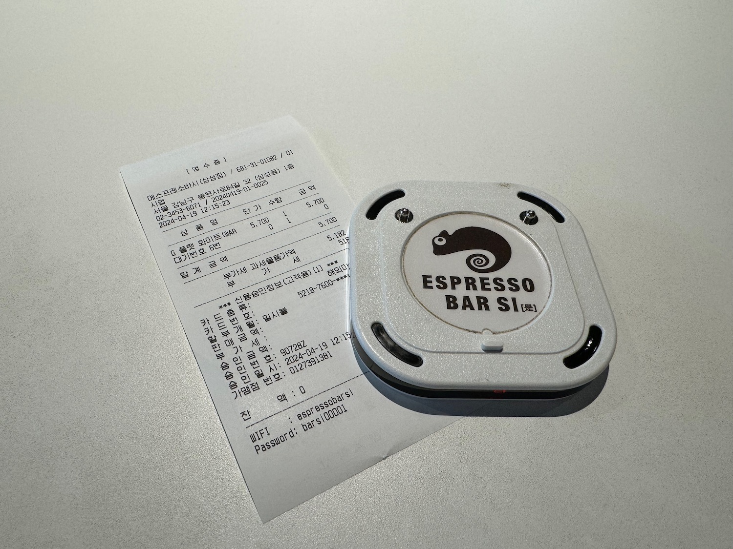 a small square object with a logo on it next to a receipt