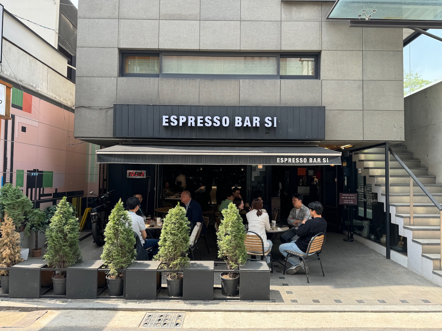 a group of people sitting at tables outside a building