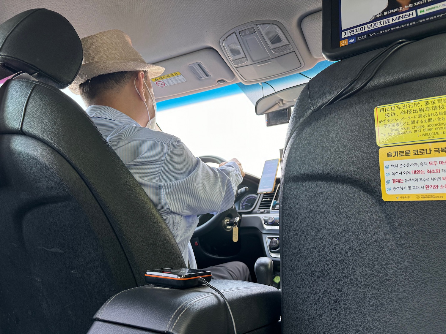 a man in a hat and headphones driving a car