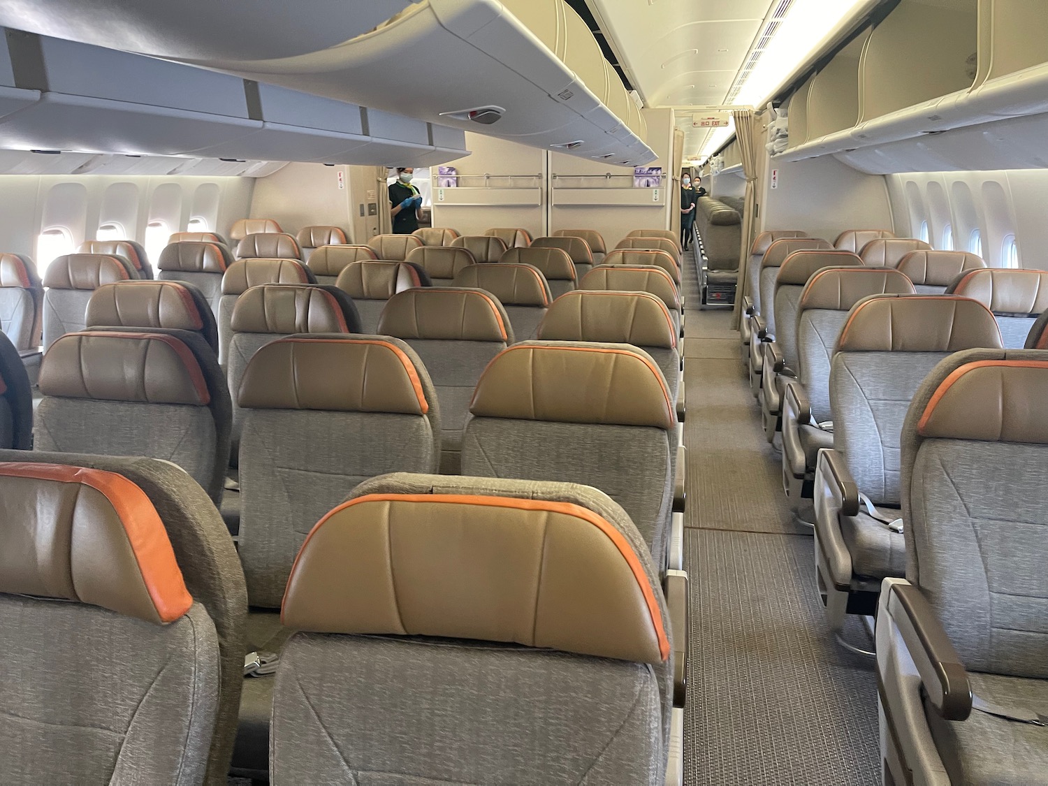 an airplane with seats and people standing in the background