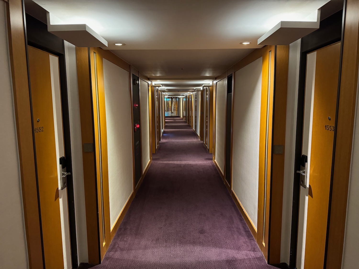 a hallway with doors and purple carpet