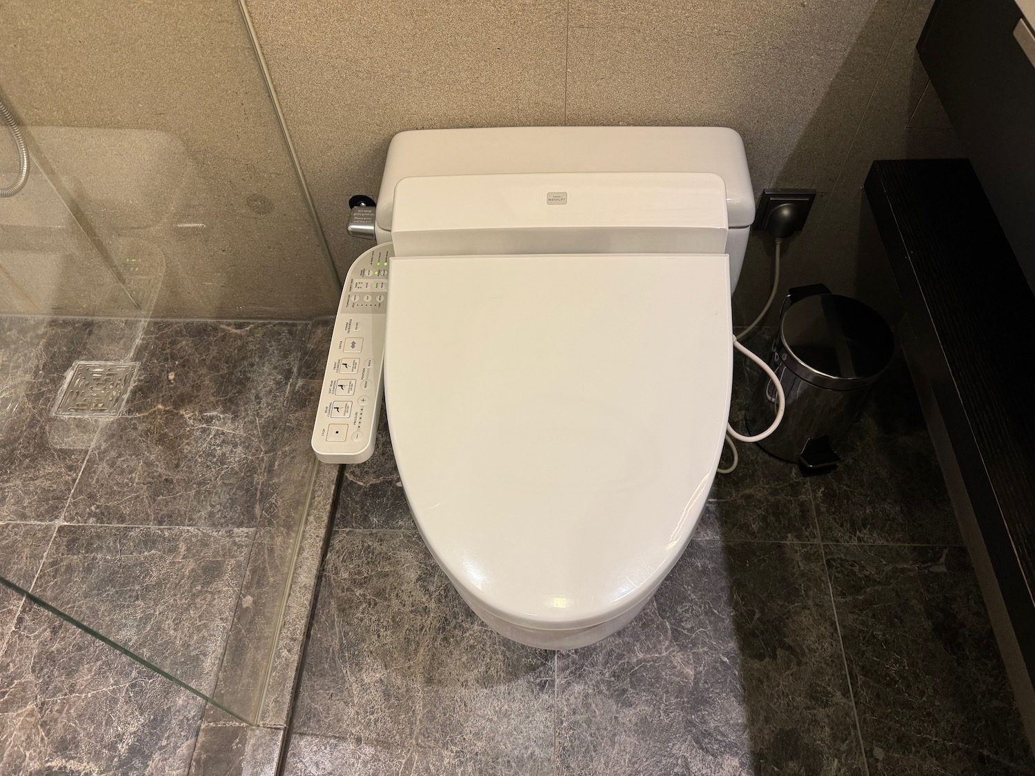 a white toilet with power strip attached to it