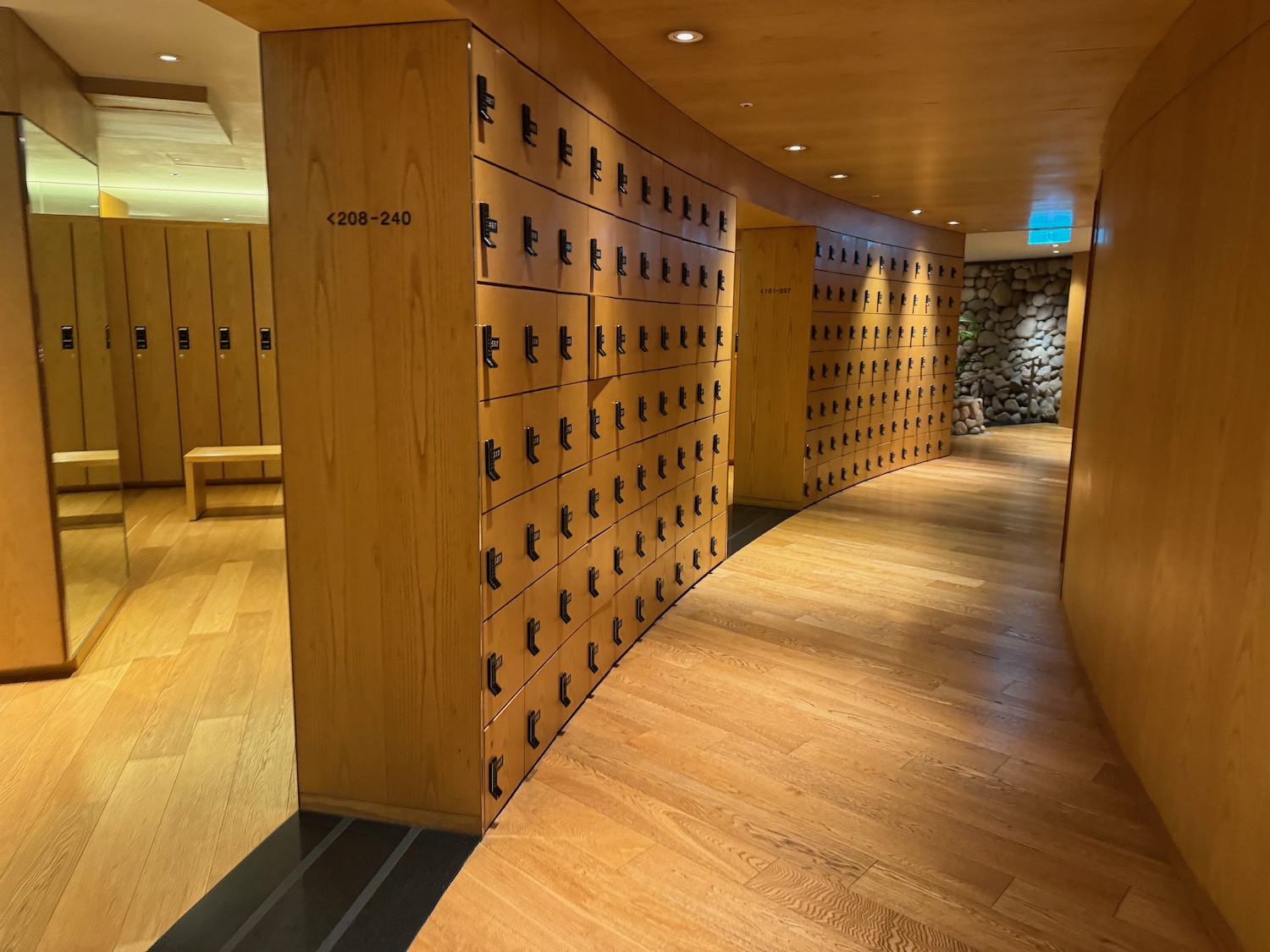 a hallway with lockers and a stone wall