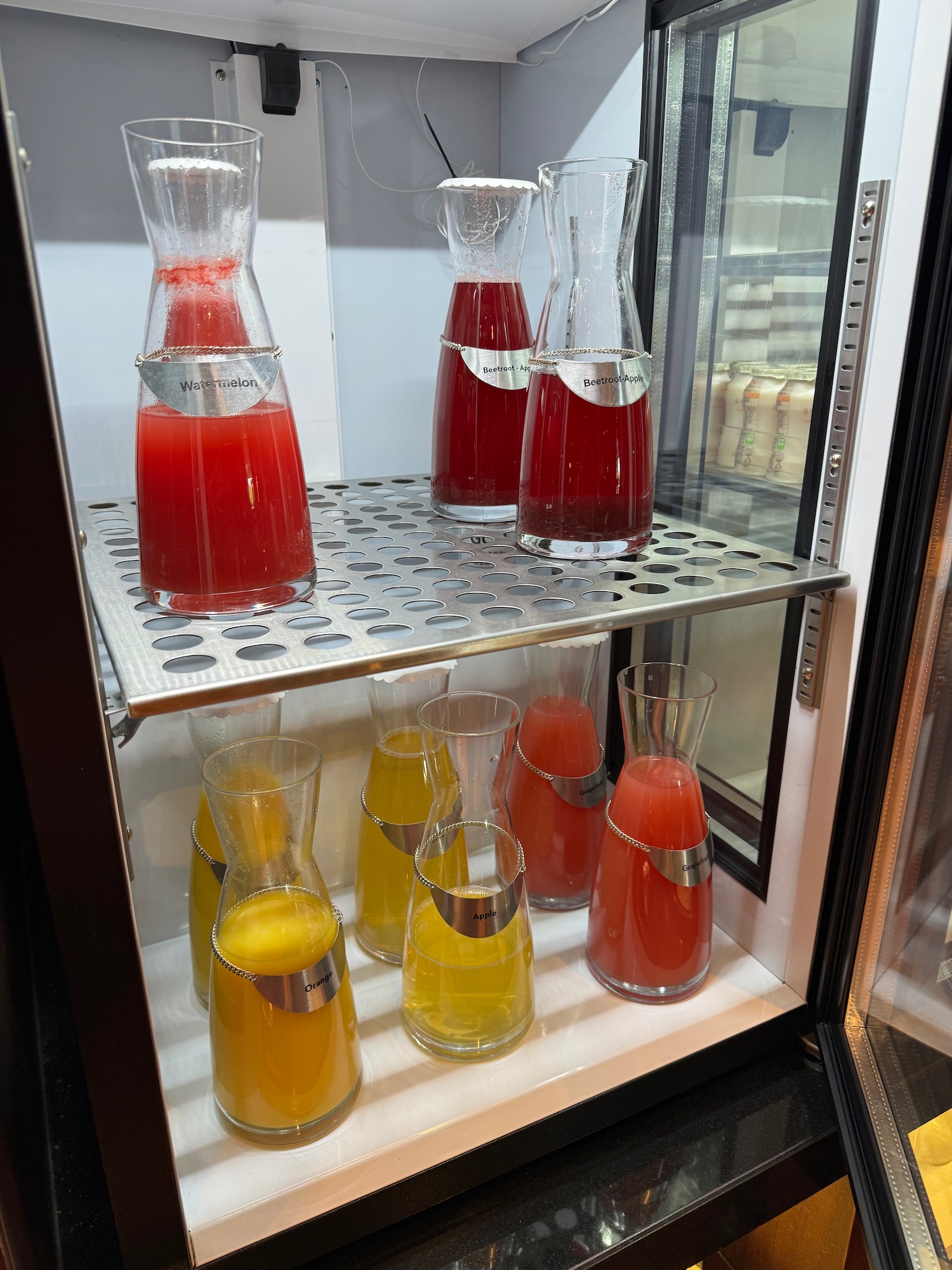 a glass display case with different colored drinks