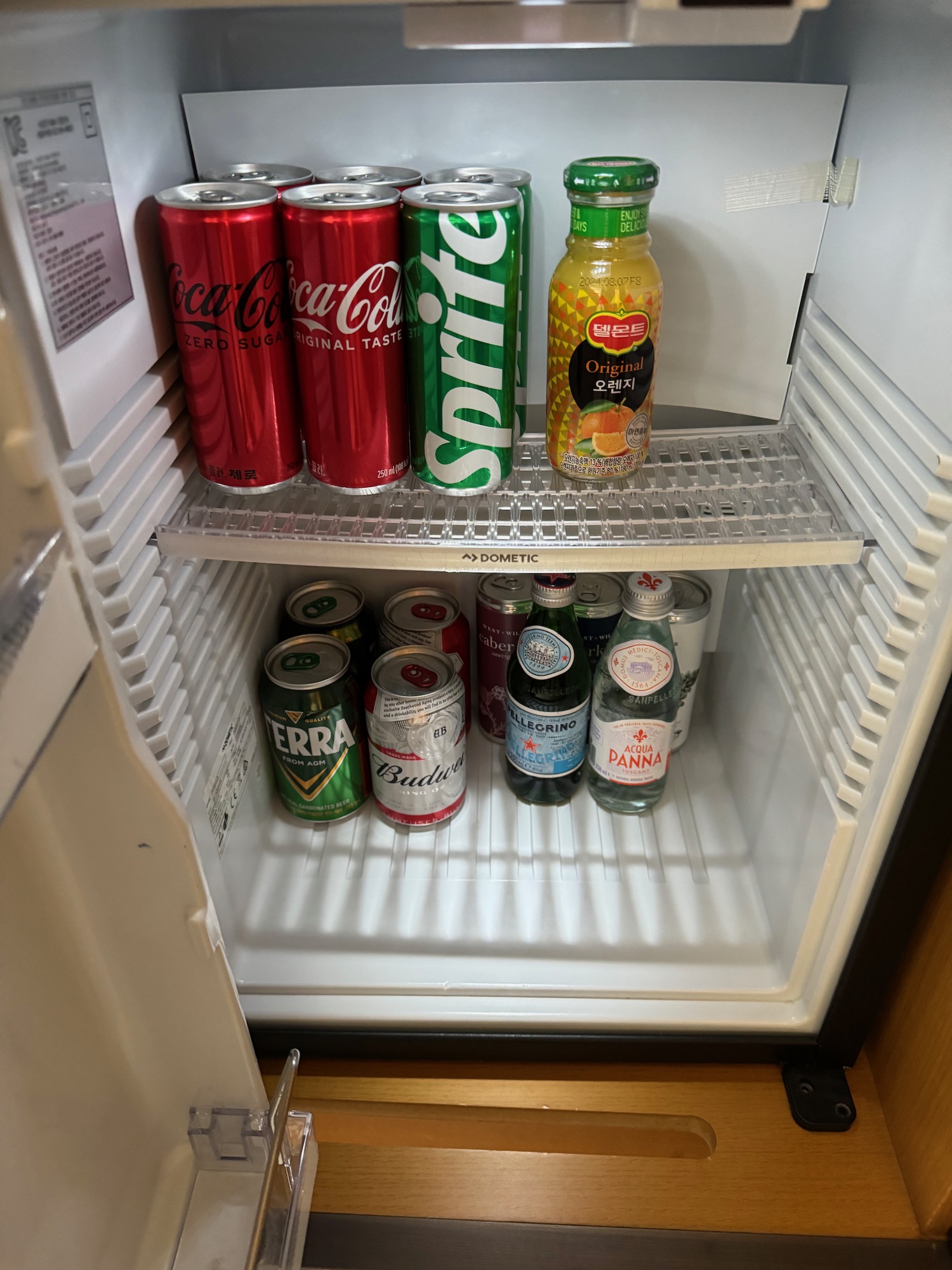 a refrigerator with cans of soda and other beverages