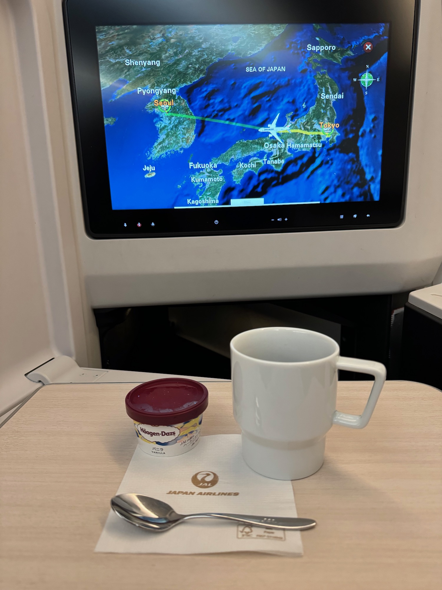 a cup and spoon on a table with a screen