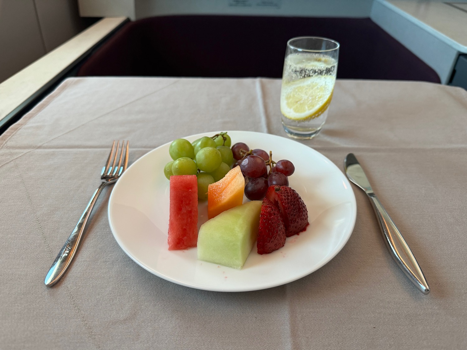 a plate of fruit and a glass of water