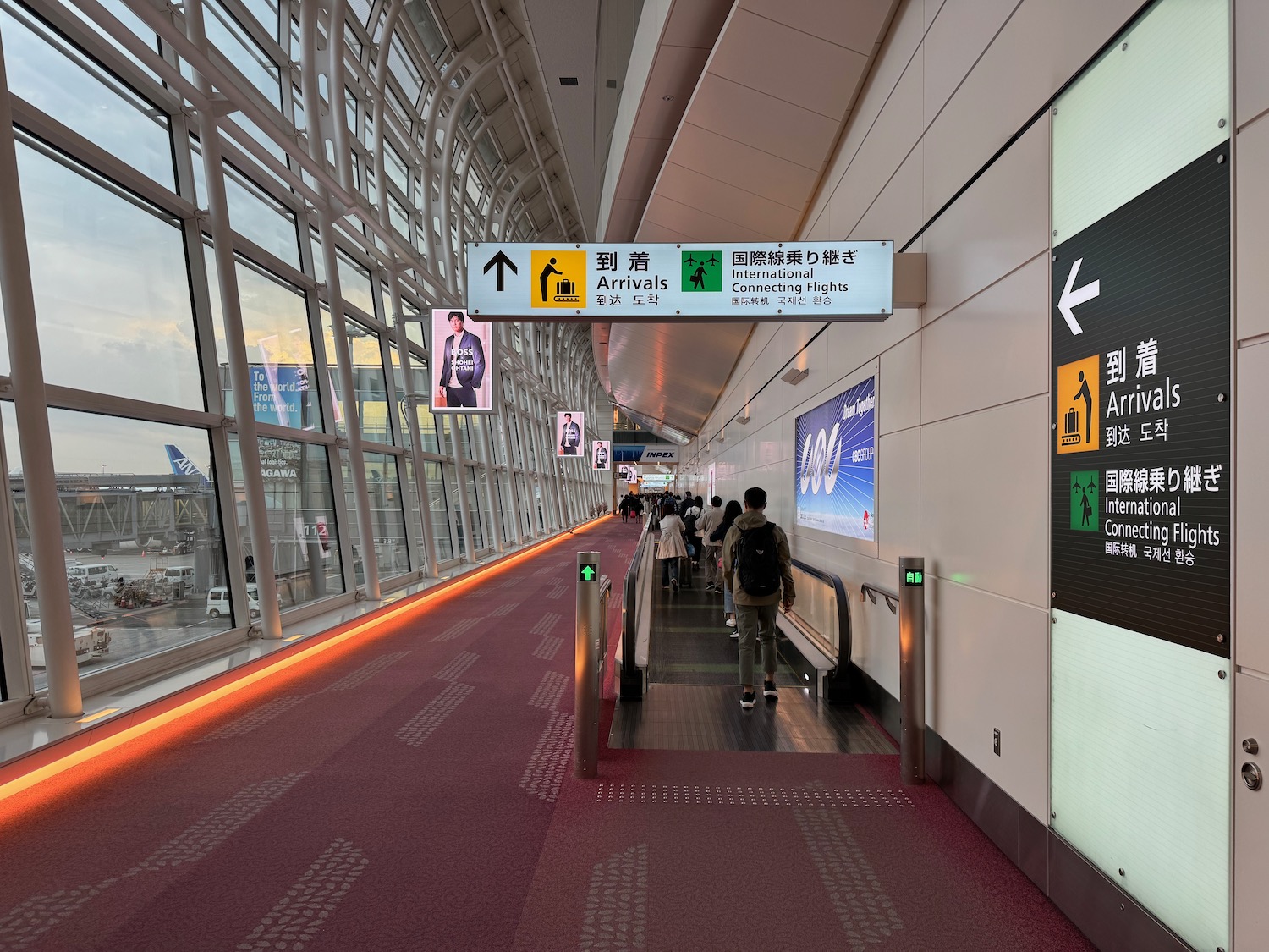 people walking down a walkway with signs and signs