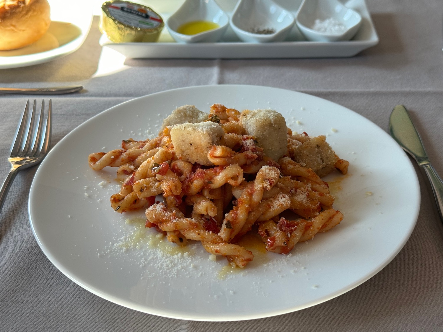 a plate of pasta with cheese and meatballs